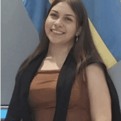 Annaliz Alexandra Cornejo Higuera smiling at the camera against a gray background.